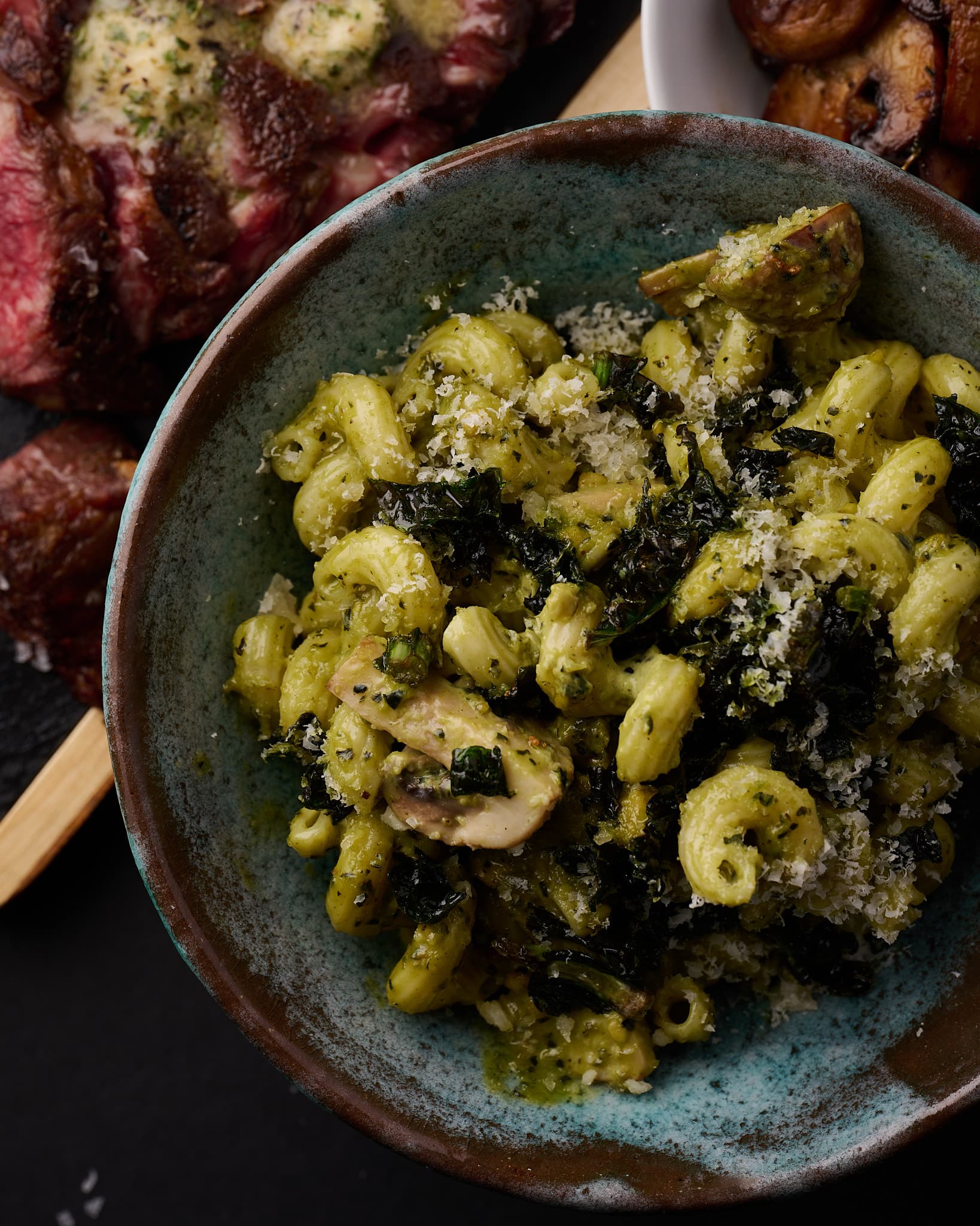 Dinner spread with pasta, steak, and wine