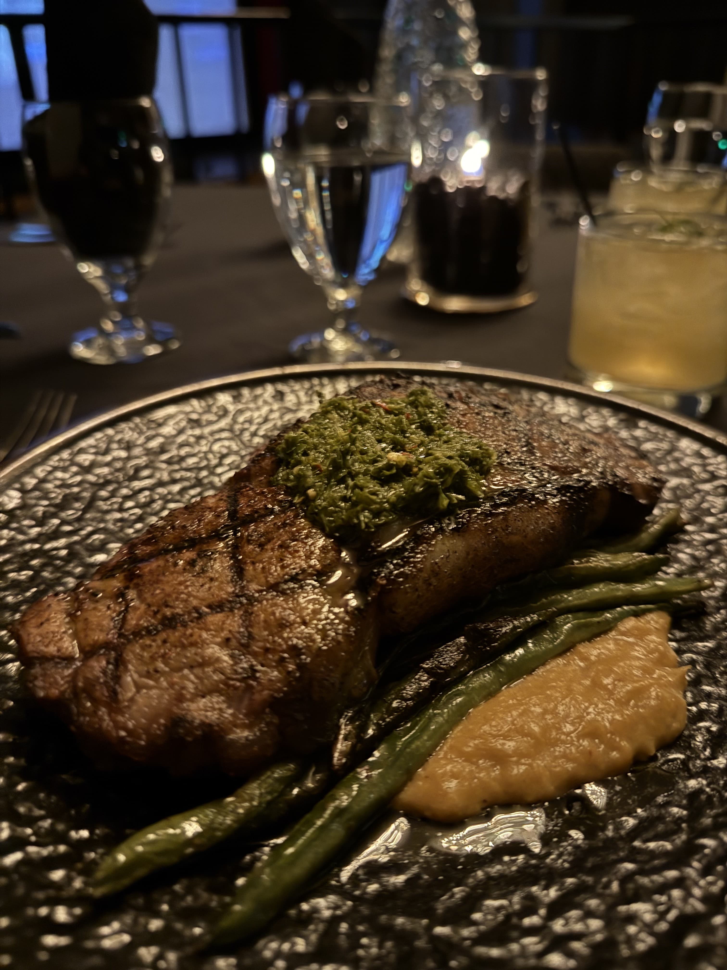 Grilled steak with chimichurri during a dinner theater show
